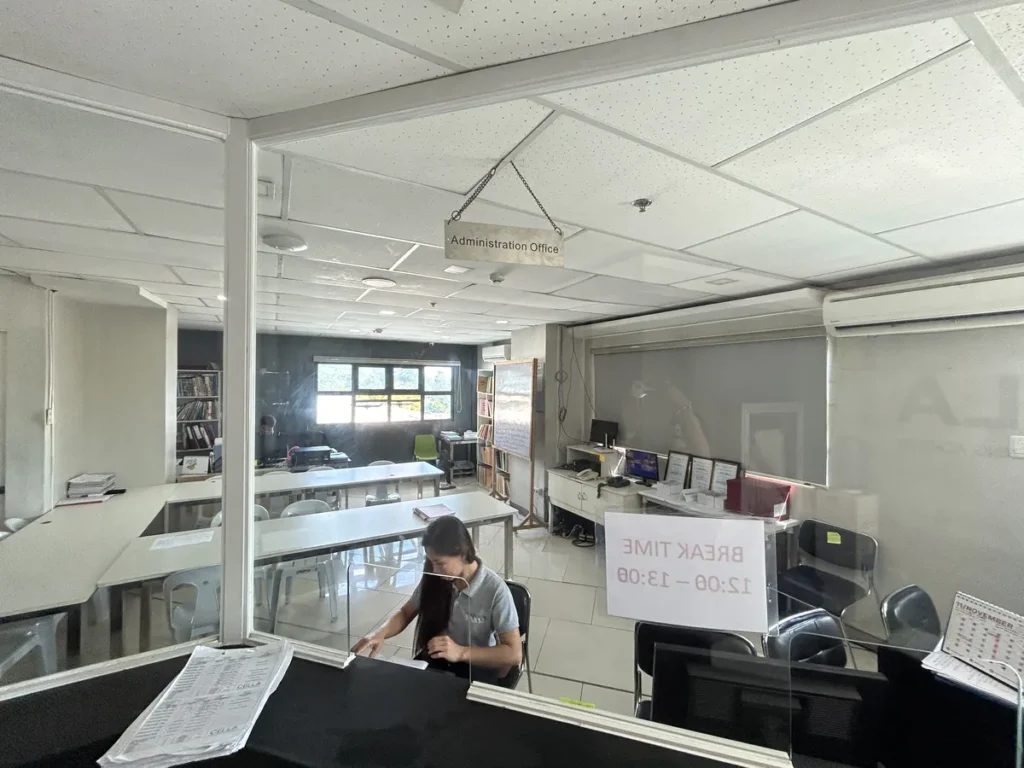 필리핀 세부 셀라(CELLA) 유니캠퍼스 어학원 부대시설 오피스로, 'Administration Office' 팻말 아래 책상과 책장이 놓인 내부입니다.