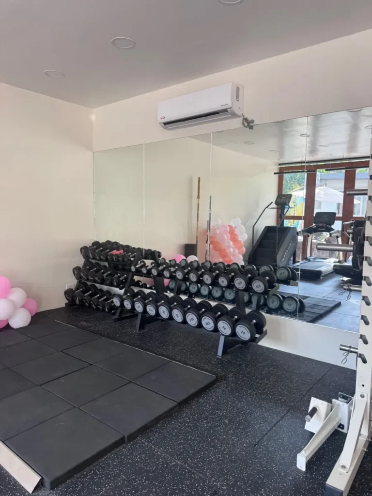 필리핀 세부 셀라(CELLA) 유니캠퍼스 어학원 운동시설 헬스장으로, 다양한 무게의 덤벨이 2단으로 정리된 랙과 거울 벽이 있는 웨이트존입니다.