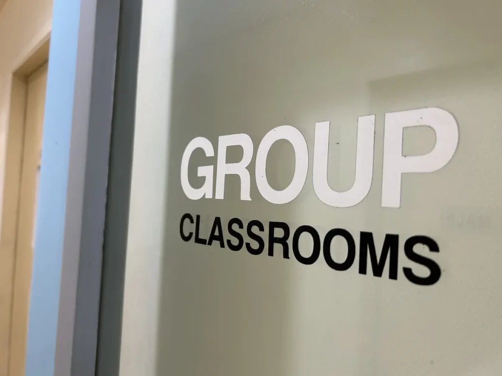 필리핀 세부 CG 바닐라드 어학원 그룹 강의실로, 유리문에 흰색과 검정색 글씨로 GROUP CLASSROOMS라고 새겨진 안내 표지판입니다.