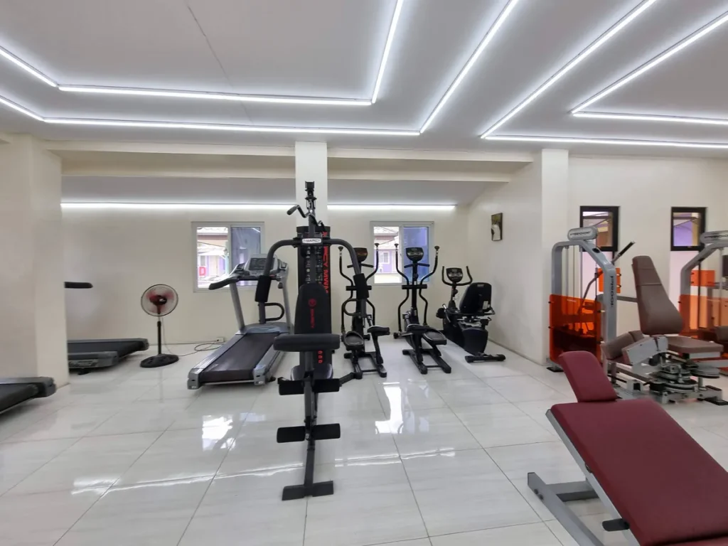 필리핀 세부 CG 바닐라드 어학원 운동시설 헬스장으로, 러닝머신과 일립티컬·복합 웨이트 머신이 창가를 따라 배열된 실내 전경입니다.