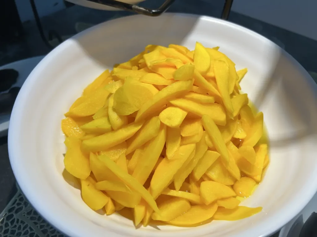 필리핀 세부 CG 바닐라드 어학원 식당 식사로, 흰 볼에 달콤한 노란 망고가 길게 슬라이스되어 소복하게 담겨 있습니다.