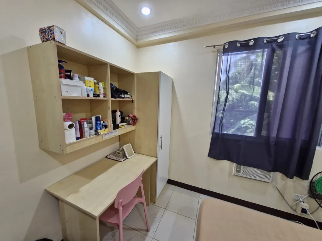 필리핀 세부 CG 스파르타 어학원 기숙사 1인실로, 세면용품이 정리된 벽선반과 책상·의자가 놓인 수납 공간 디테일입니다.