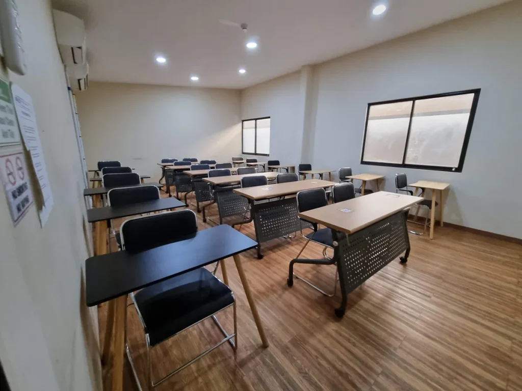 필리핀 세부 CG 스파르타 어학원 강의실 그룹반으로, 원목 무늬 바닥과 검정색 의자·책상이 여러 줄로 놓인 넓은 강의 공간입니다.