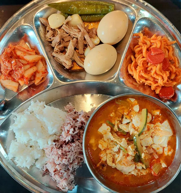 필리핀 세부 JJES 어학원 학생식당 식사로, 장조림·메추리알과 매콤 잡채, 김치에 흰쌀밥·잡곡밥과 김치계란국을 곁들인 식판입니다.