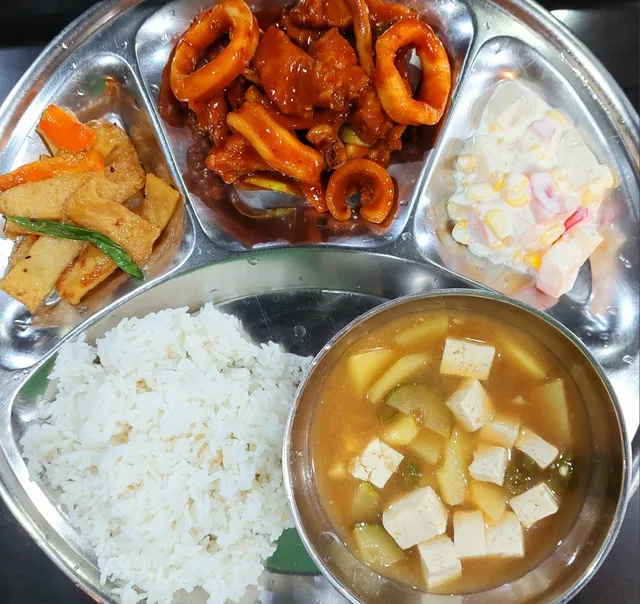 필리핀 세부 JJES 어학원 학생식당 식사로, 두부조림과 매콤 오징어볶음·콘샐러드에 흰쌀밥과 된장국을 곁들인 식판입니다.