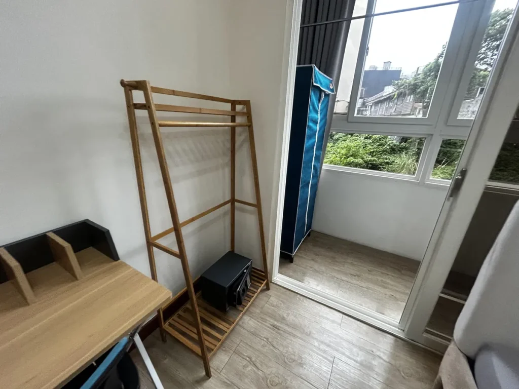 필리핀 바기오 웨일즈(WALES) 어학원 기숙사 1인실 스튜디오(2인가족)로, 원목 행거와 파란 원단 옷장이 놓인 수납 공간입니다.