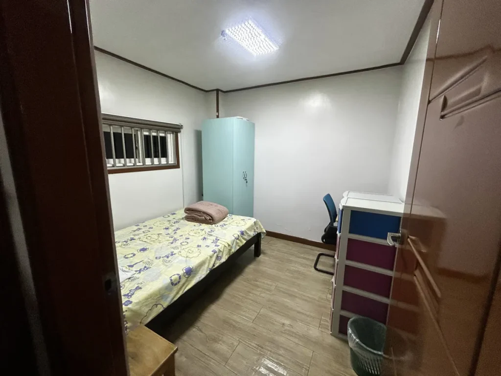 필리핀 바기오 웨일즈(WALES) 어학원 기숙사 1인실 공유형으로, 문 앞에서 본 민트색 옷장과 싱글 침대, 책상·서랍장이 있는 방 전체입니다.