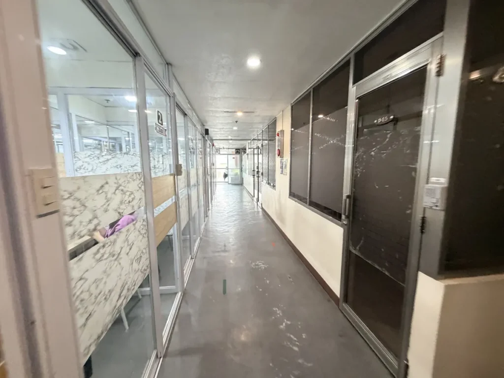필리핀 바기오 웨일즈(WALES) 어학원 기숙사 복도(저층)로, 대리석 무늬 객실과 방문 번호판이 보이는 저층 복도입니다.