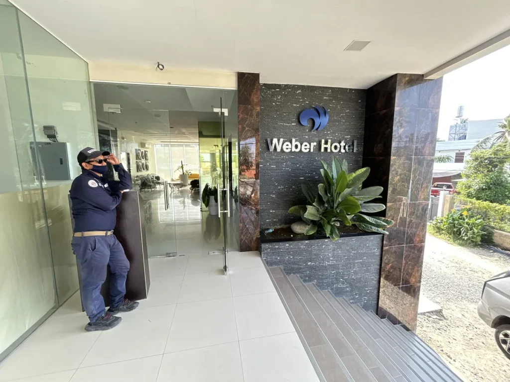 필리핀 세부 CIJ 어학원 외부숙소 외관으로, Weber Hotel 간판과 화단 옆 유리문 입구에 경비원이 서 있는 건물 출입구입니다.