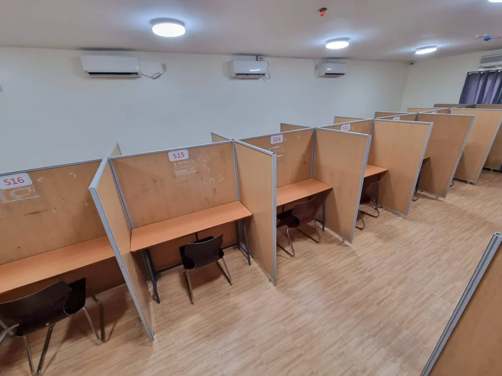 필리핀 세부 CIJ 어학원 자습실로, 번호가 붙은 칸막이 1인 책상이 줄지어 있고 벽면에 에어컨 여러 대가 설치된 넓은 공간입니다.