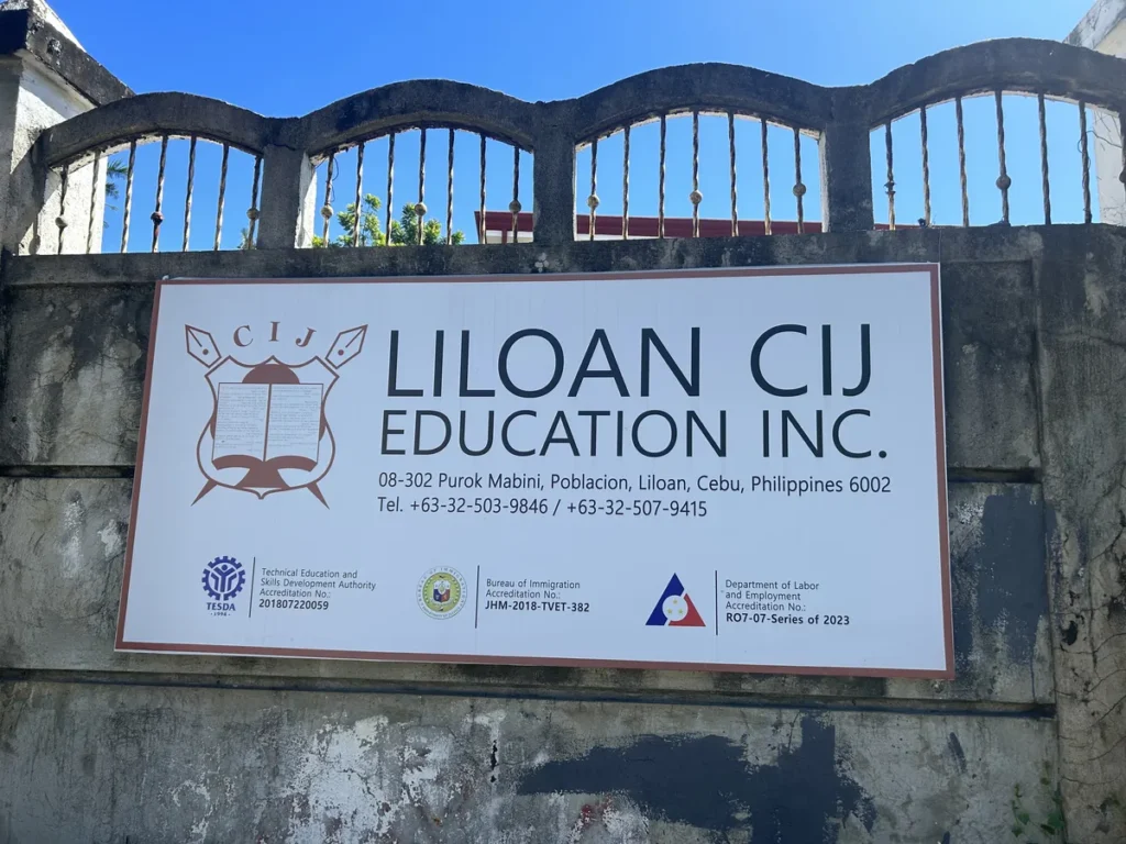 필리핀 세부 CIJ 어학원 외관으로, 담장에 걸린 LILOAN CIJ EDUCATION INC. 간판에 주소와 연락처·인가 기관 정보가 적힌 모습입니다.