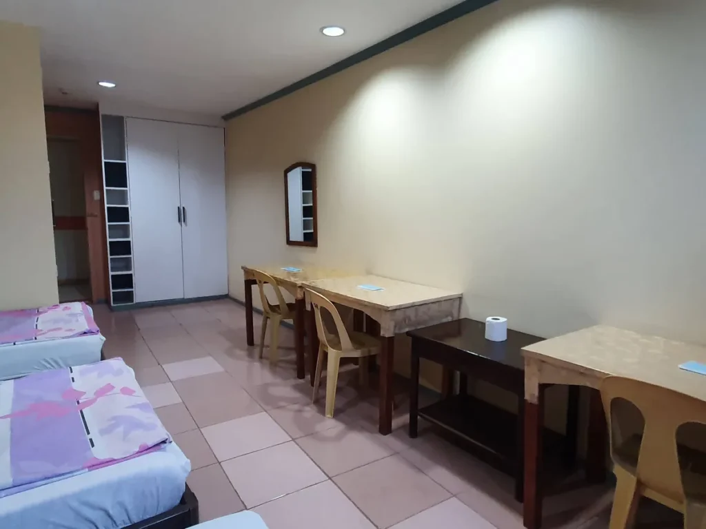 필리핀 세부 시필스(CPILS) 어학원 기숙사 3인실 일반룸으로, 흰 2문 옷장과 수납 선반, 거울 아래 나란히 놓인 책상과 의자가 보이는 모습입니다.