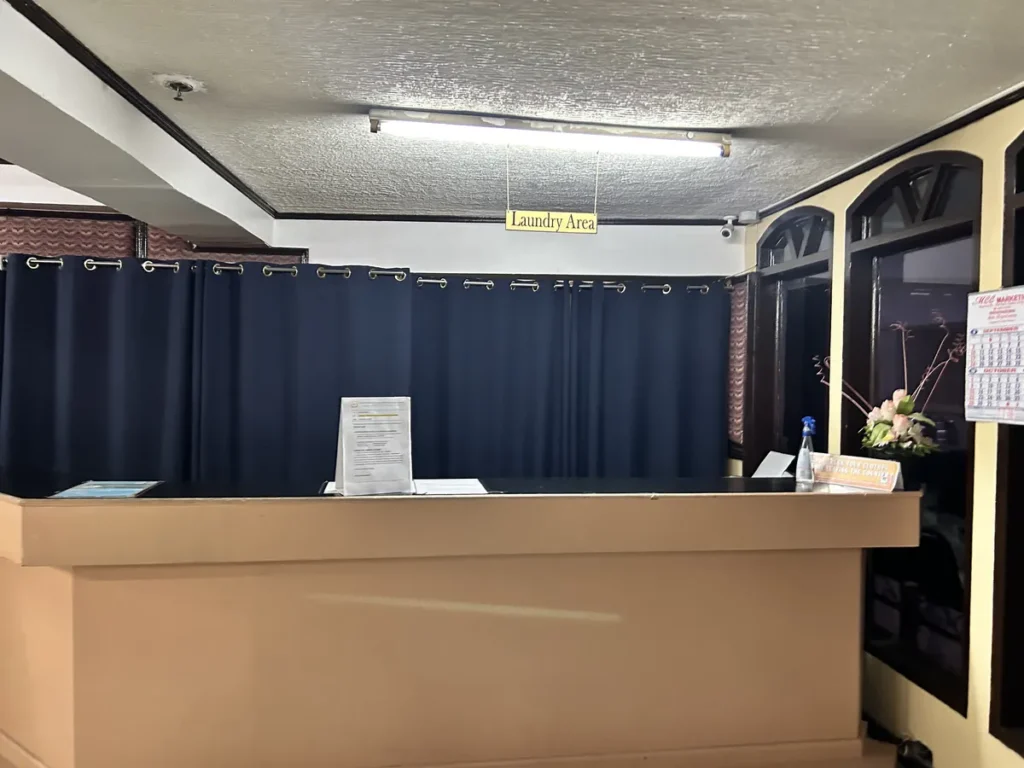 필리핀 세부 시필스(CPILS) 어학원 세탁실로, Laundry Area 표지 아래 세탁물을 맡기는 접수 카운터와 안내문이 놓여 있습니다.