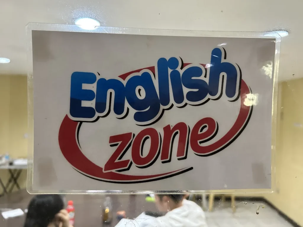 필리핀 세부 시필스(CPILS) 어학원 안내판으로, 유리문에 붙은 영어 사용 구역 English zone 표지판을 가까이에서 찍은 모습입니다.
