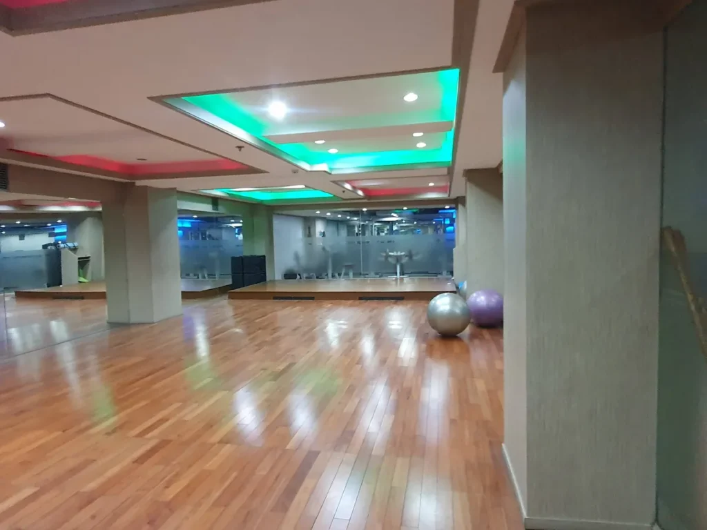 필리핀 세부 시필스(CPILS) 어학원 요가장으로, 윤이 나는 원목 바닥과 거울 벽, 짐볼이 놓이고 천장에 색 조명이 들어간 넓은 공간입니다.