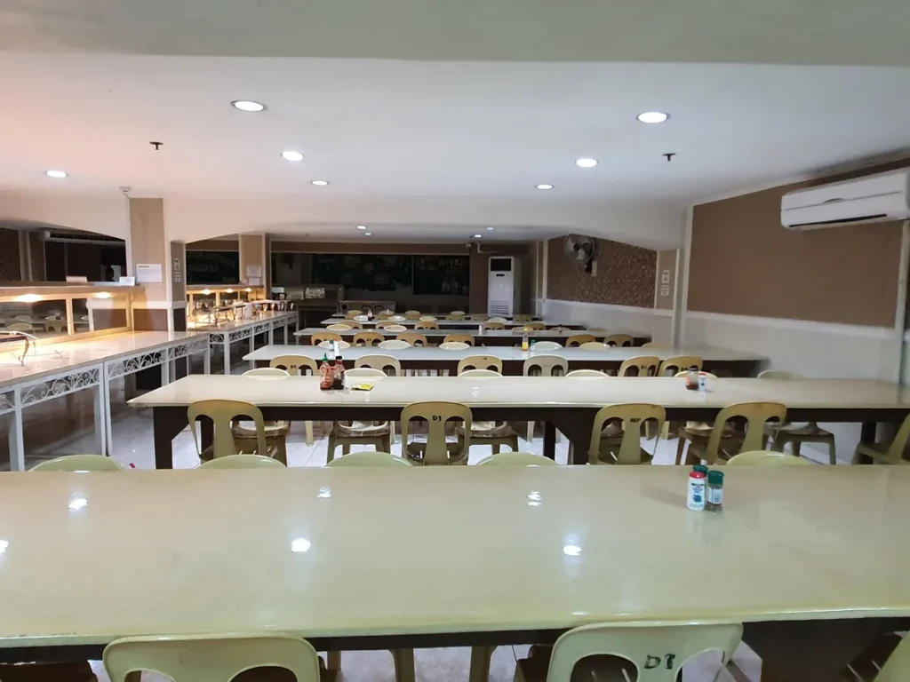 필리핀 세부 시필스(CPILS) 어학원 식당으로, 소스와 양념통이 놓인 긴 테이블들이 벽걸이 에어컨 아래 나란히 배치된 모습입니다.