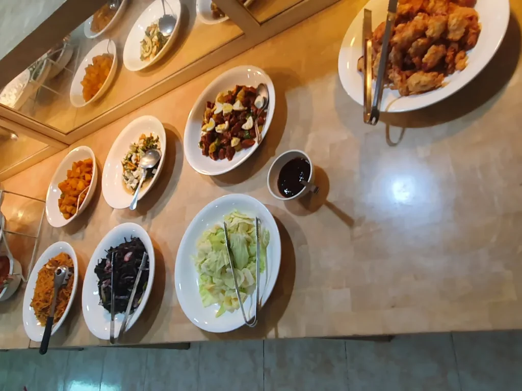 필리핀 세부 시필스(CPILS) 어학원 식당 식사 메뉴로, 위에서 내려다본 대리석 배식대에 닭튀김·계란 넣은 고기볶음·채소 반찬이 놓인 모습입니다.
