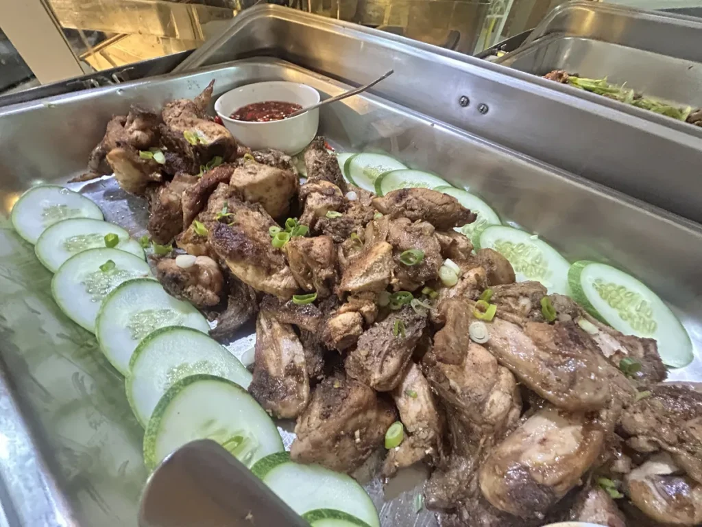 필리핀 세부 시필스(CPILS) 어학원 식당 식사 메뉴로, 송송 썬 파를 올린 닭구이 둘레에 오이를 두르고 매콤한 소스 그릇을 놓은 요리입니다.