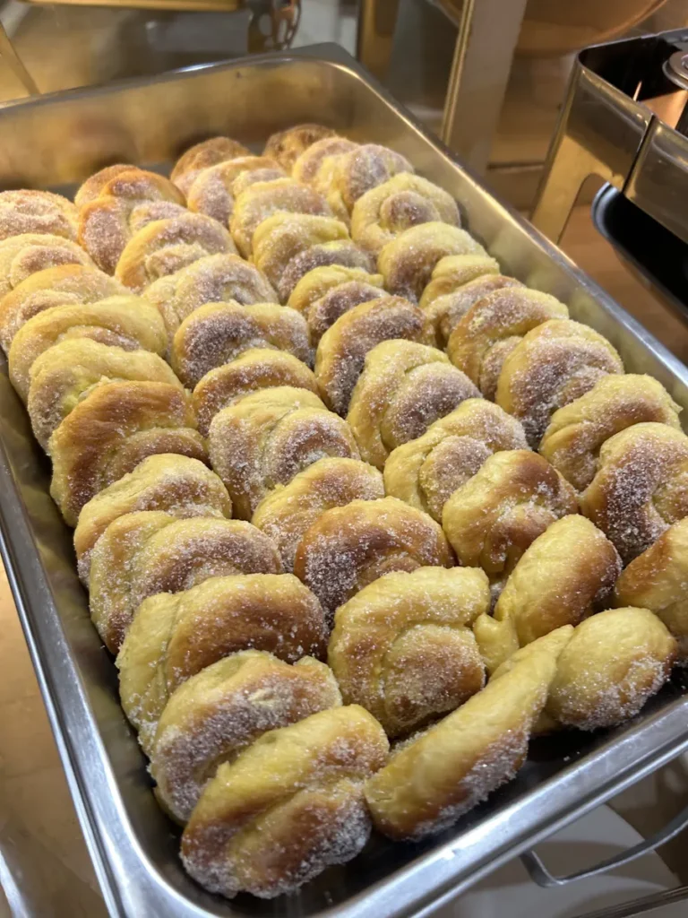 필리핀 세부 시필스(CPILS) 어학원 식당 식사 메뉴로, 설탕을 묻힌 꽈배기 모양 빵이 스테인리스 트레이에 가지런히 줄지어 담긴 모습입니다.