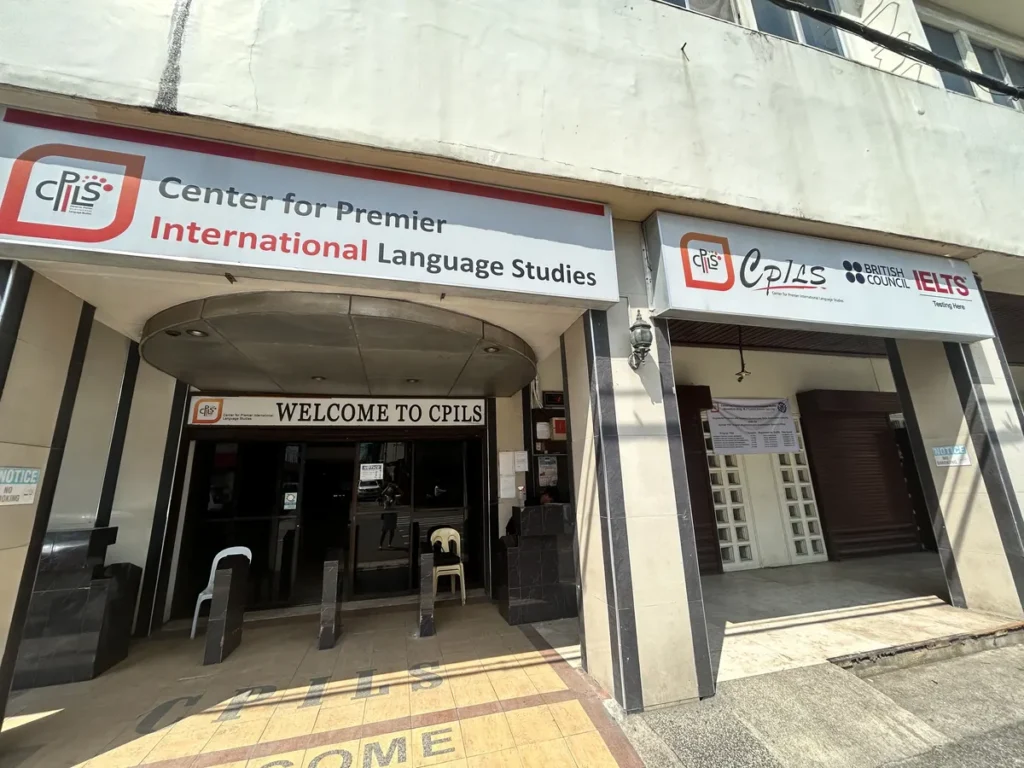 필리핀 세부 시필스(CPILS) 어학원 건물 외관으로, WELCOME TO CPILS 현관과 IELTS 시험장 간판이 나란히 걸린 정문입니다.